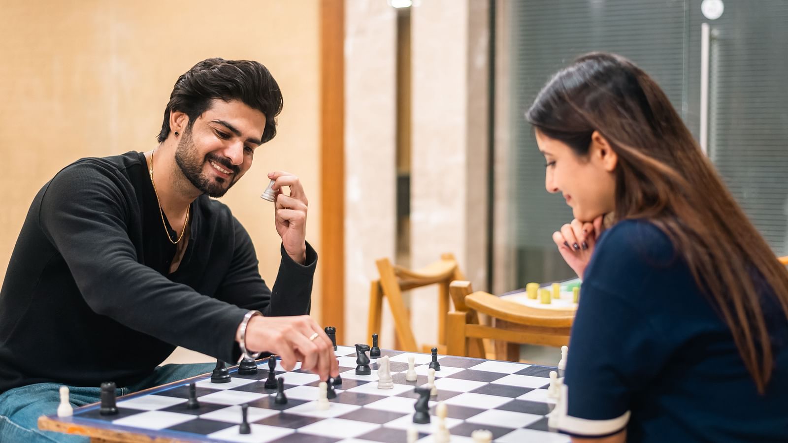  Couple immersed in a friendly chess match, part of indoor recreational activities at The Grand Legacy Resort and Spa.