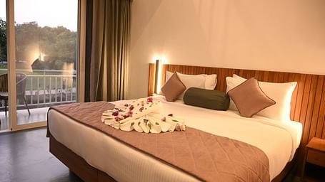 Side view of a double bed at the Kutumbh Suite at Mango Leaf Lake Resort, Pune