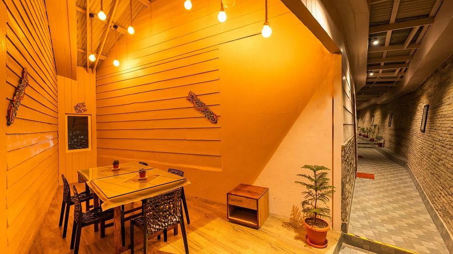 Candle light dinner room with a table arranged in corner and side by there is passage at Arcadia Heritage Resort, Darjeeling.