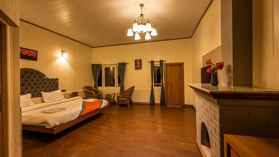 A comfortable Double Room with spacious room with plushy bed, table, chandelier at Arcadia Heritage Resort, Darjeeling. 