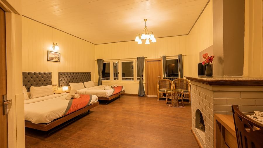 A spacious family room with 2 comfy beds, table, chimney at Arcadia Heritage Resort, Darjeeling
