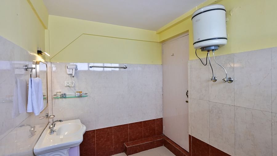 3Premium rooms bathroom equipped with a washbasin, mirror, geyser, and western toilet at Avianna Seven Seas, Darjeeling