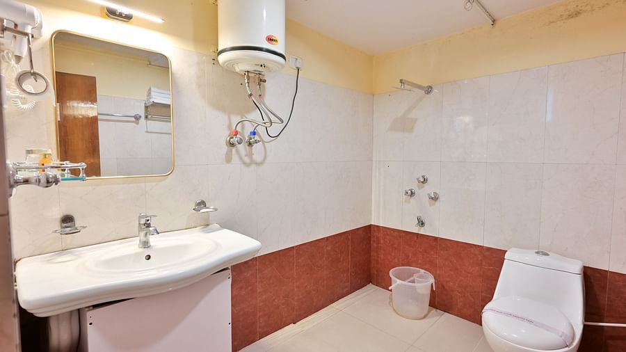 4Premium rooms bathroom equipped with a washbasin, mirror, geyser, and western toilet at Avianna Seven Seas, Darjeeling