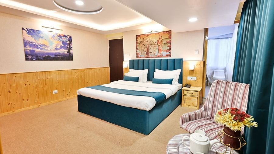 Deluxe Room with spacious bed, wooden furniture and warm lighitng at Avianna Seven Seas, Darjeeling4