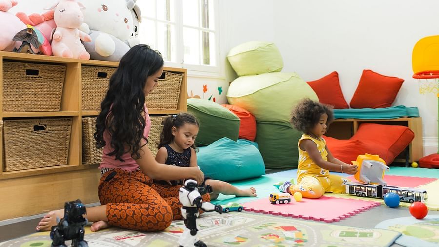 A woman and children are playing in a room filled with toys | Central Mansions, Phnom Penh
