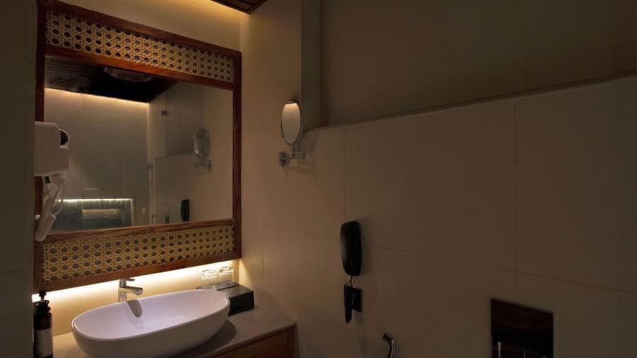 Image of bathroom of Coral Sapphire at Coral Reef Resort and Spa in Havelock featuring a sink with a mirror over it and a tiny mirror mounted on the wall next to it