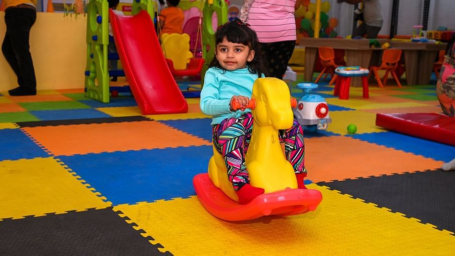 Young child playing on a colorful indoor playground slide | Diamond Parks, Pune