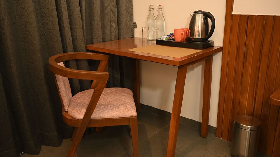 A chair and a table with Tea & Coffee maker at the Deluxe Cottage at Mango Leaf Lake Resort, Pune