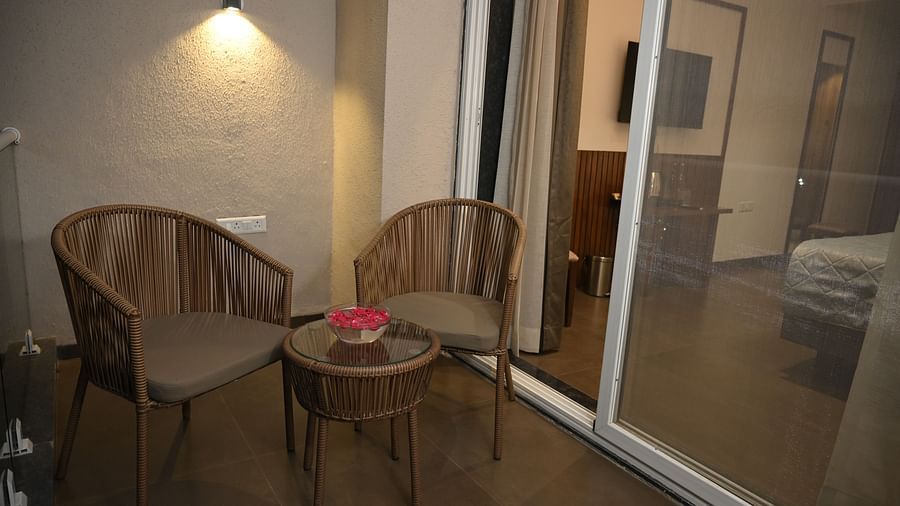 Two chairs and a small tea table outside the Deluxe room at  Mango Leaf Lake Resort, Pune