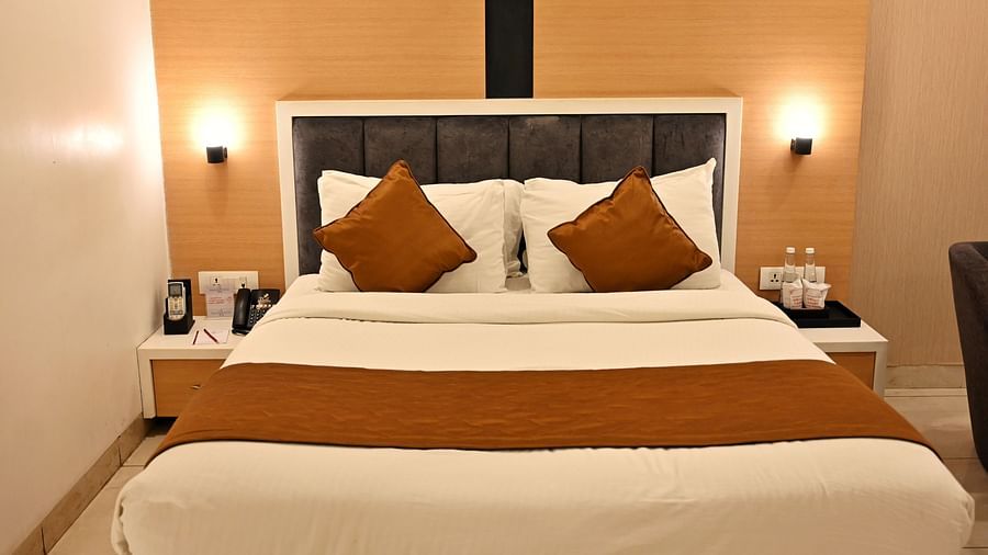 A contemporary bedroom with a plush headboard and coordinated brown accent pillows - TGI Insignia, Bhopal