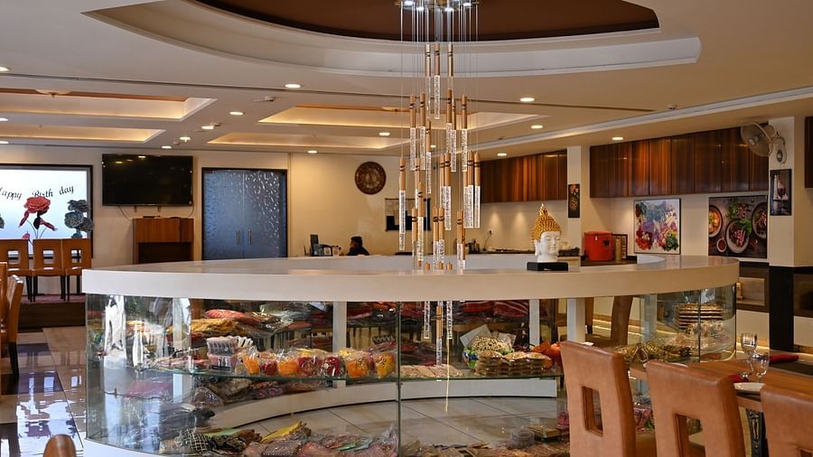 Another view of a hotel restaurant interior with circular centre piece display under a modern chandelier - TGI Insignia, Bhopal
