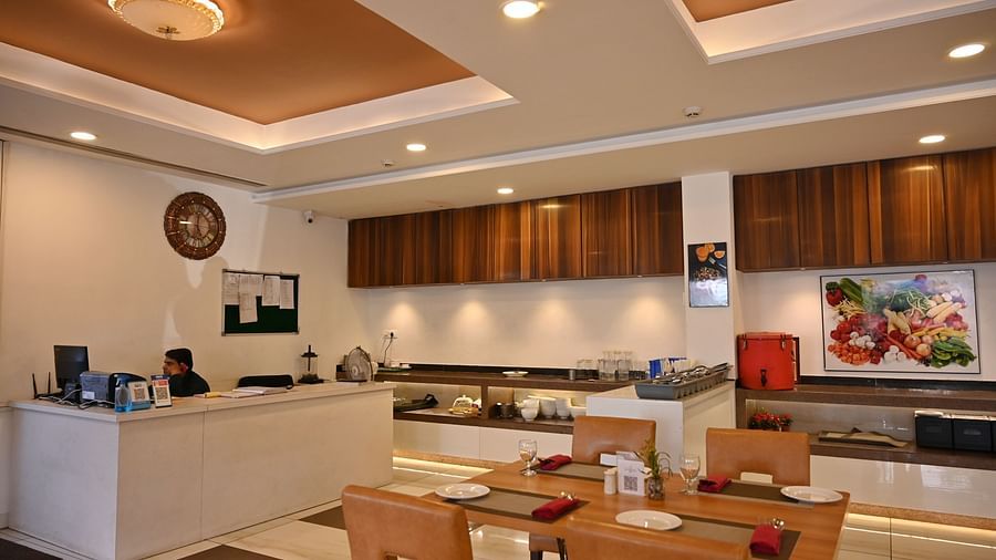 A hotel restaurant with tables set for dining and a service counter in the background - TGI Insignia, Bhopal
