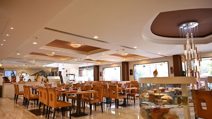 Hotel dining area with neatly arranged tables, contemporary art and a service counter - TGI Insignia, Bhopal