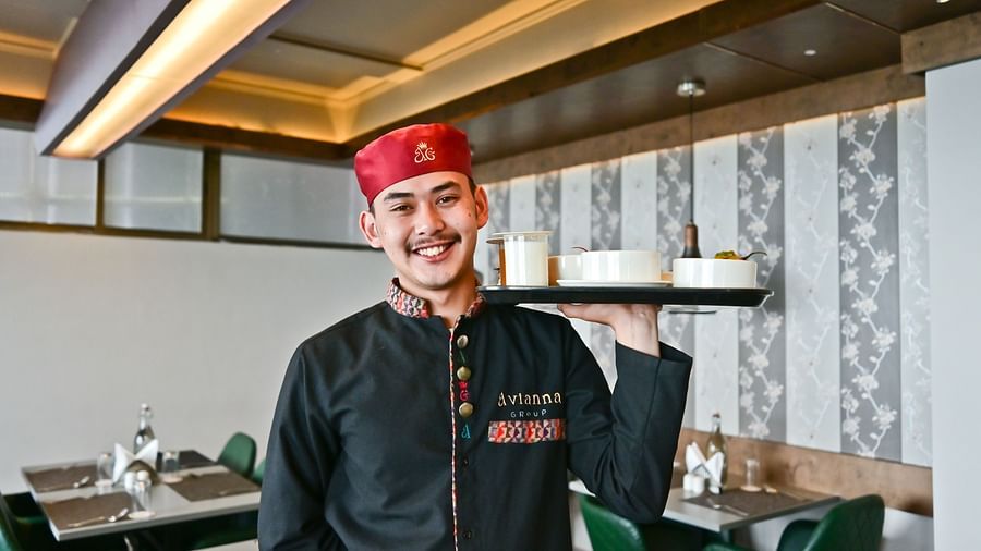 Image of a man holding a tray of food at The Soma Hotel by Avianna Group, Darjeeling