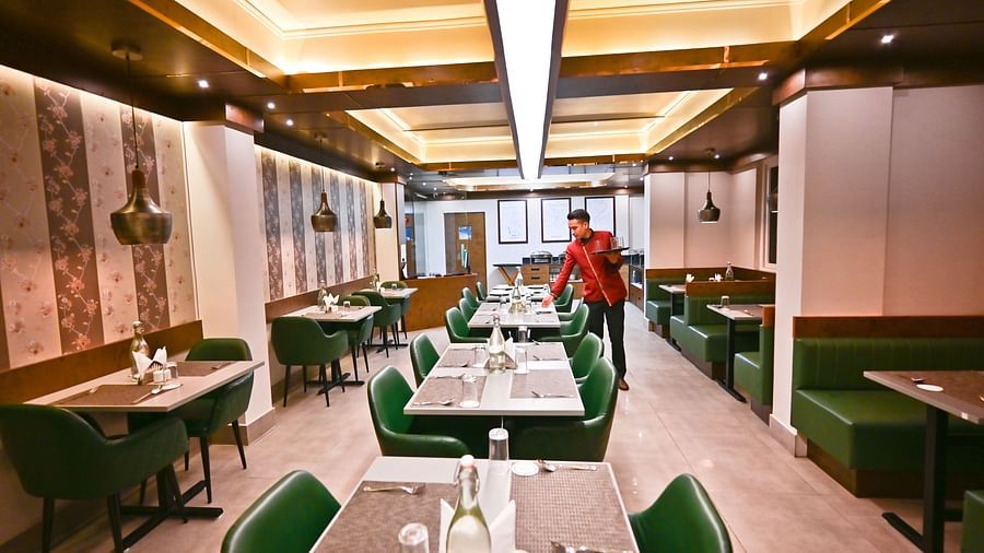 Image of a restaurant with a man serving  at The Soma Hotel by Avianna Group, Darjeeling