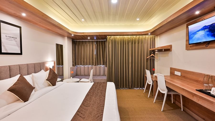 premium rooms with a sitting area and two white chairs at the soma hotel by avianna group, darjeeling