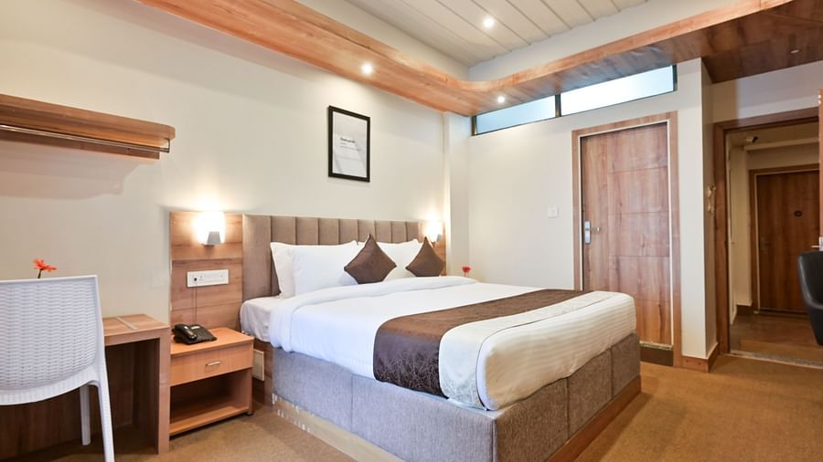 deluxe room with a work desk and a white chair at the soma hotel by avianna group, darjeeling