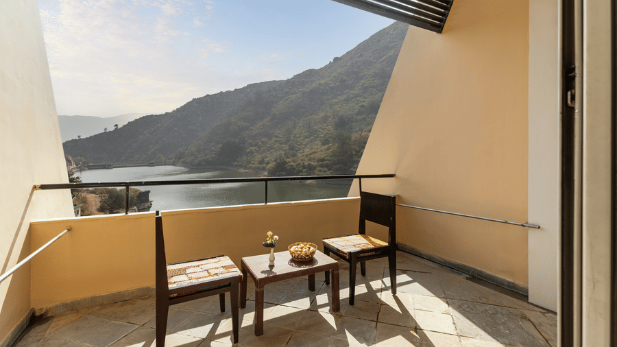 A balcony view with neatly arranged table and chairs under a sunny day - Via Lakhela Resort & Spa