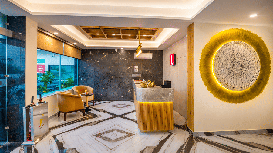 Inside Lords Inn Katra, the reception lobby features a wooden ceiling, a marble floor, plush armchairs next to large glass windows.