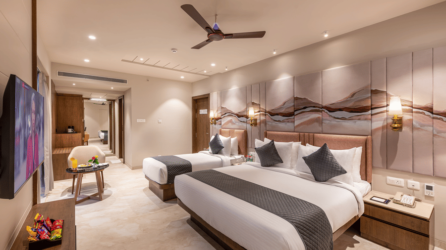 A wide-angle shot of the Family Room with a king size bed and an additional single bed – Skkylight Lords Inn, Nanded