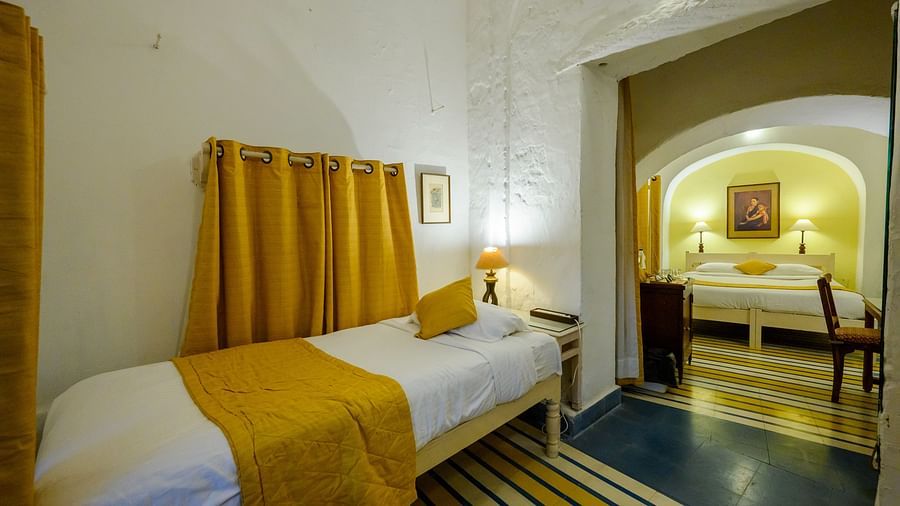 Hill Fort Kesroli 14th Century Alwar - interior view of the Swagat Mahal room wit a single bed and yellow decor