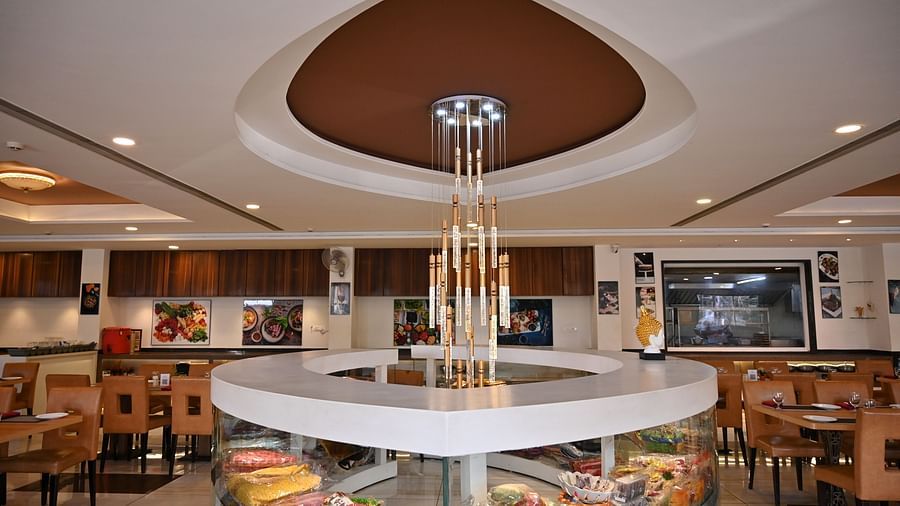 Hotel restaurant interior with circular centre piece display under a modern chandelier - TGI Insignia, Bhopal
