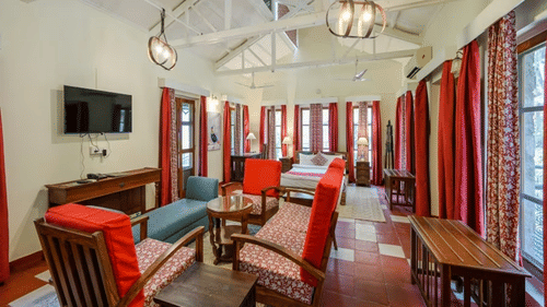 An overview of a room with a double bed and chairs in front of it - Neemrana's Glasshouse on the Ganges, Rishikesh