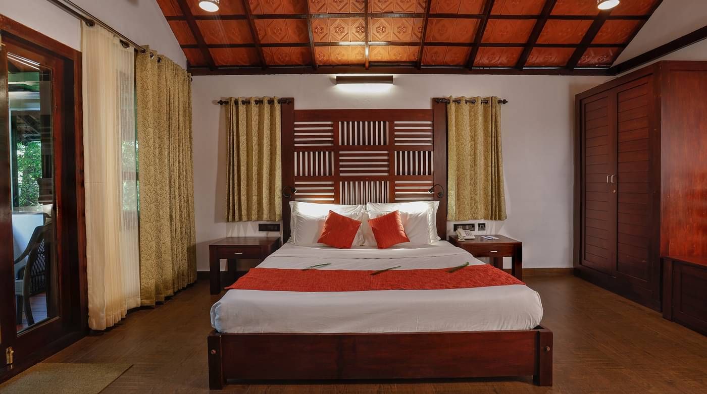 A front view of a bed in a bedroom | Vythiri Resort. Wayanad