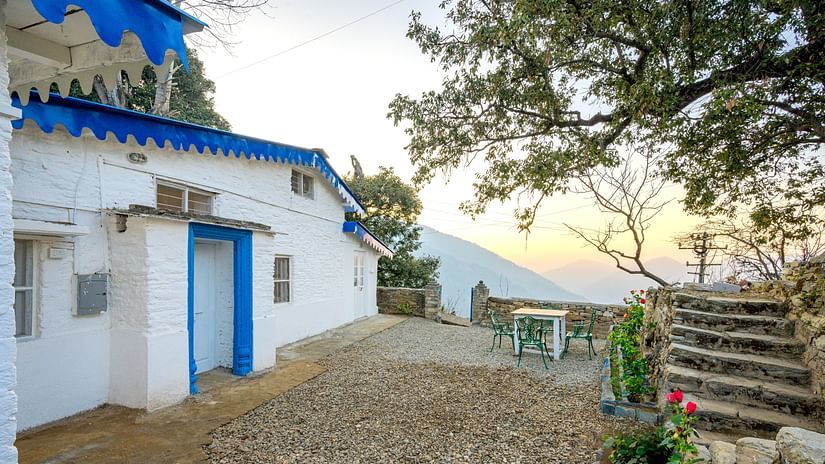 Facade view of blue cottage with steps opposite it - Ramgarh Bungalows, Nainital.