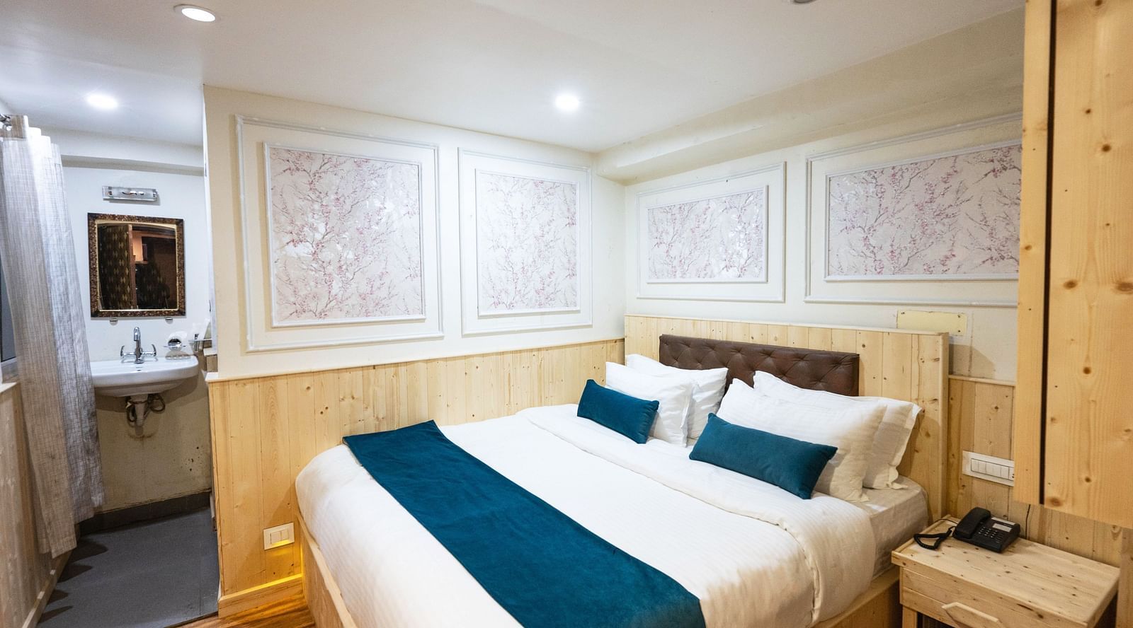 an image of a standard room with a king size bed and a phone line next to it  on a table at Avianna New Mandala Hotel & Spa, Darjeeling