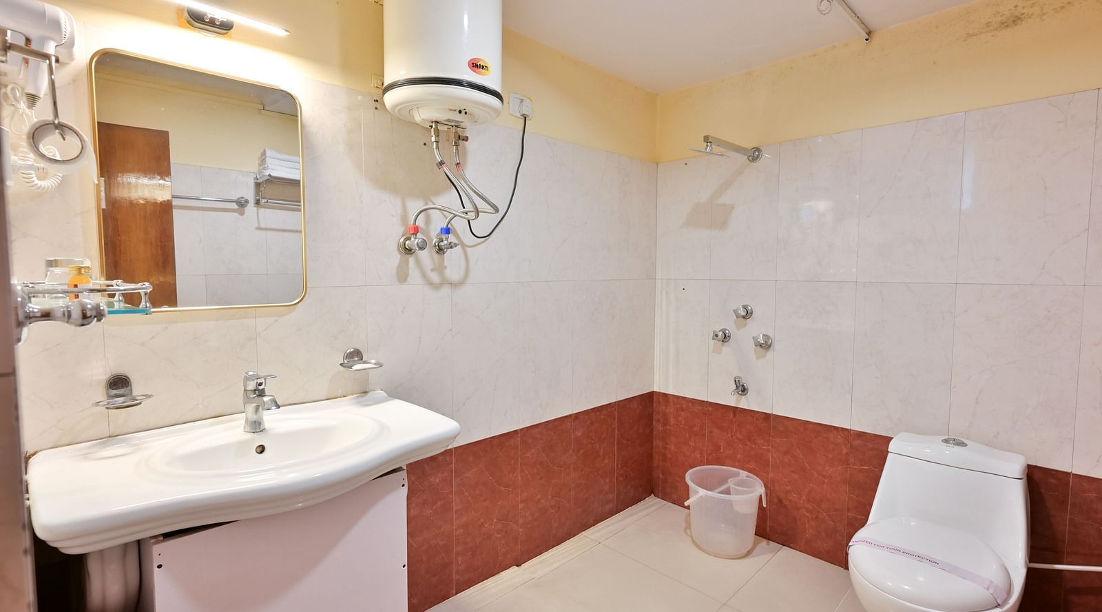 4Premium rooms bathroom equipped with a washbasin, mirror, geyser, and western toilet at Avianna Seven Seas, Darjeeling