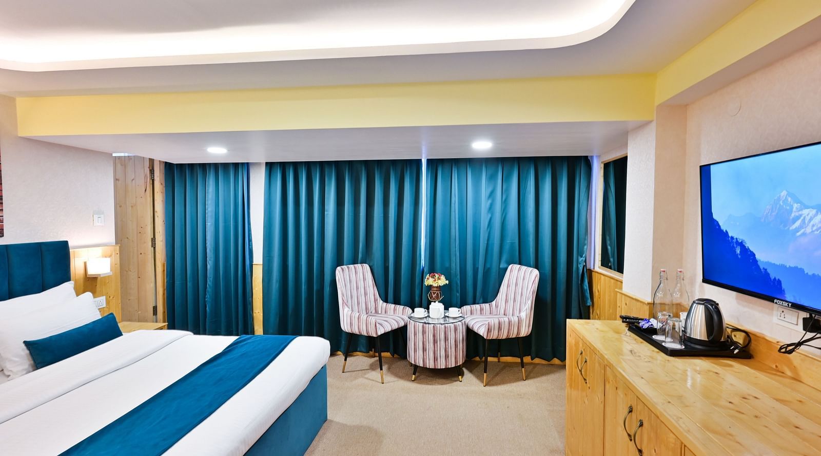 Deluxe Room with spacious bed, wooden furniture and warm lighitng at Avianna Seven Seas, Darjeeling3