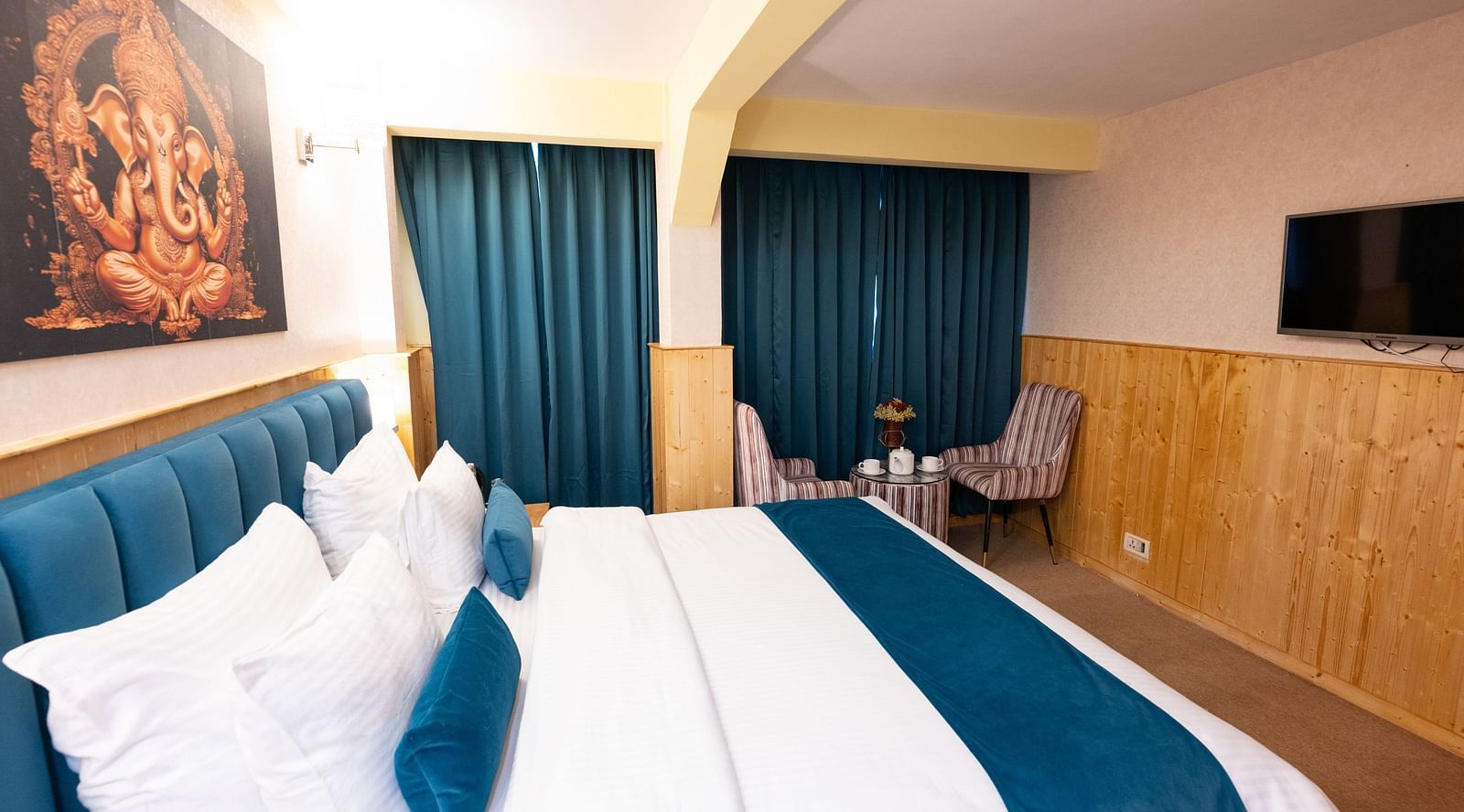 Deluxe Room with spacious bed, wooden furniture and warm lighitng at Avianna Seven Seas, Darjeeling9