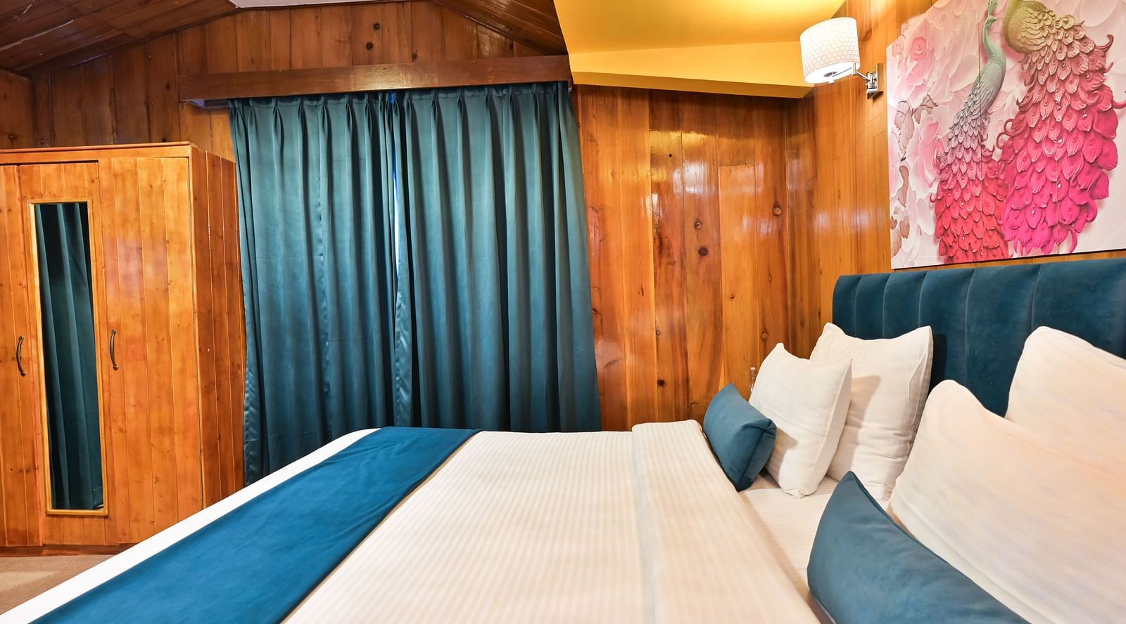 Premium room featuring a king sized bed, wall mounted television, windows with curtains, and warm lighting at Avianna Seven Seas, Darjeeling13