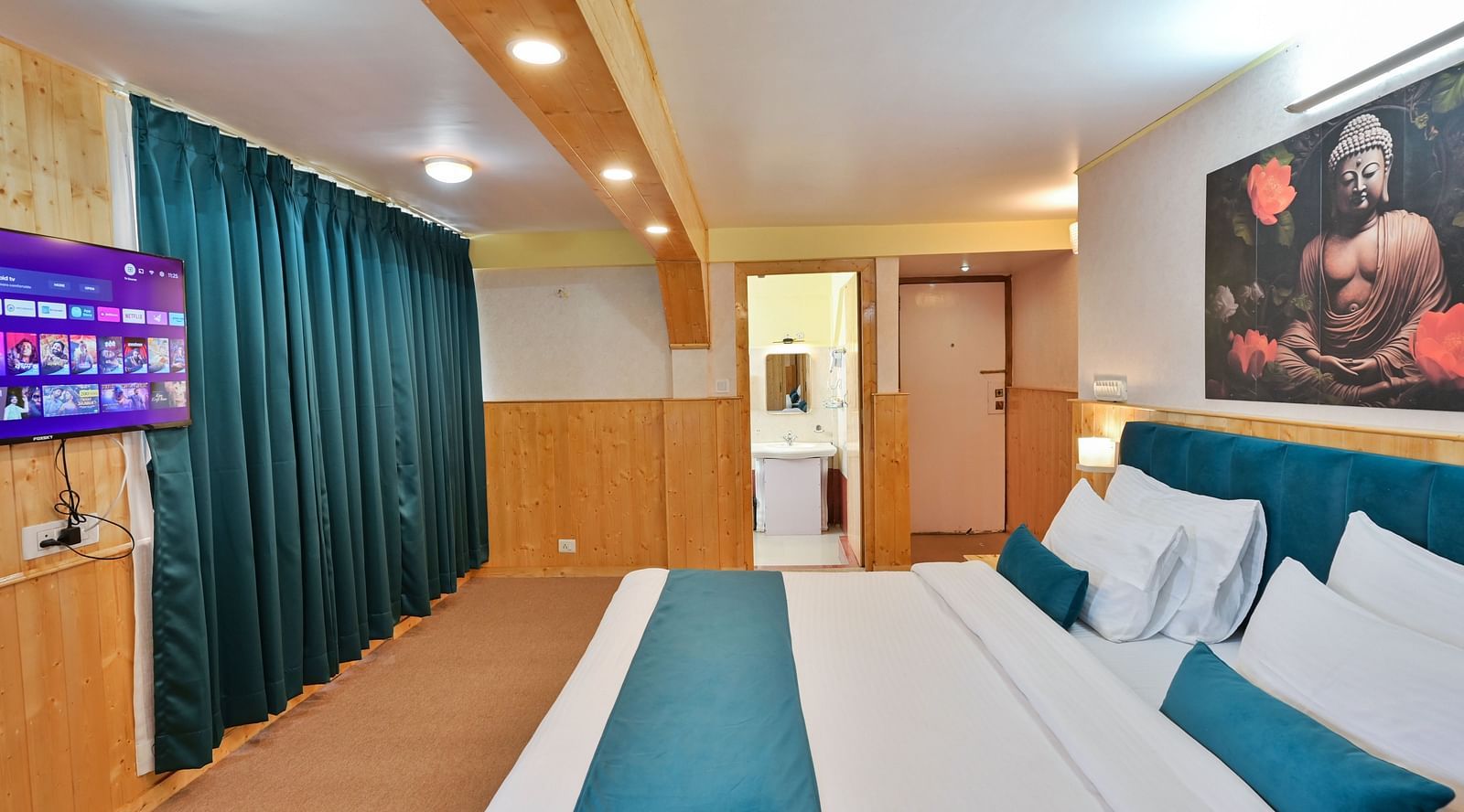 Premium room featuring a king sized bed, wall mounted television, windows with curtains, and warm lighting at Avianna Seven Seas, Darjeeling9