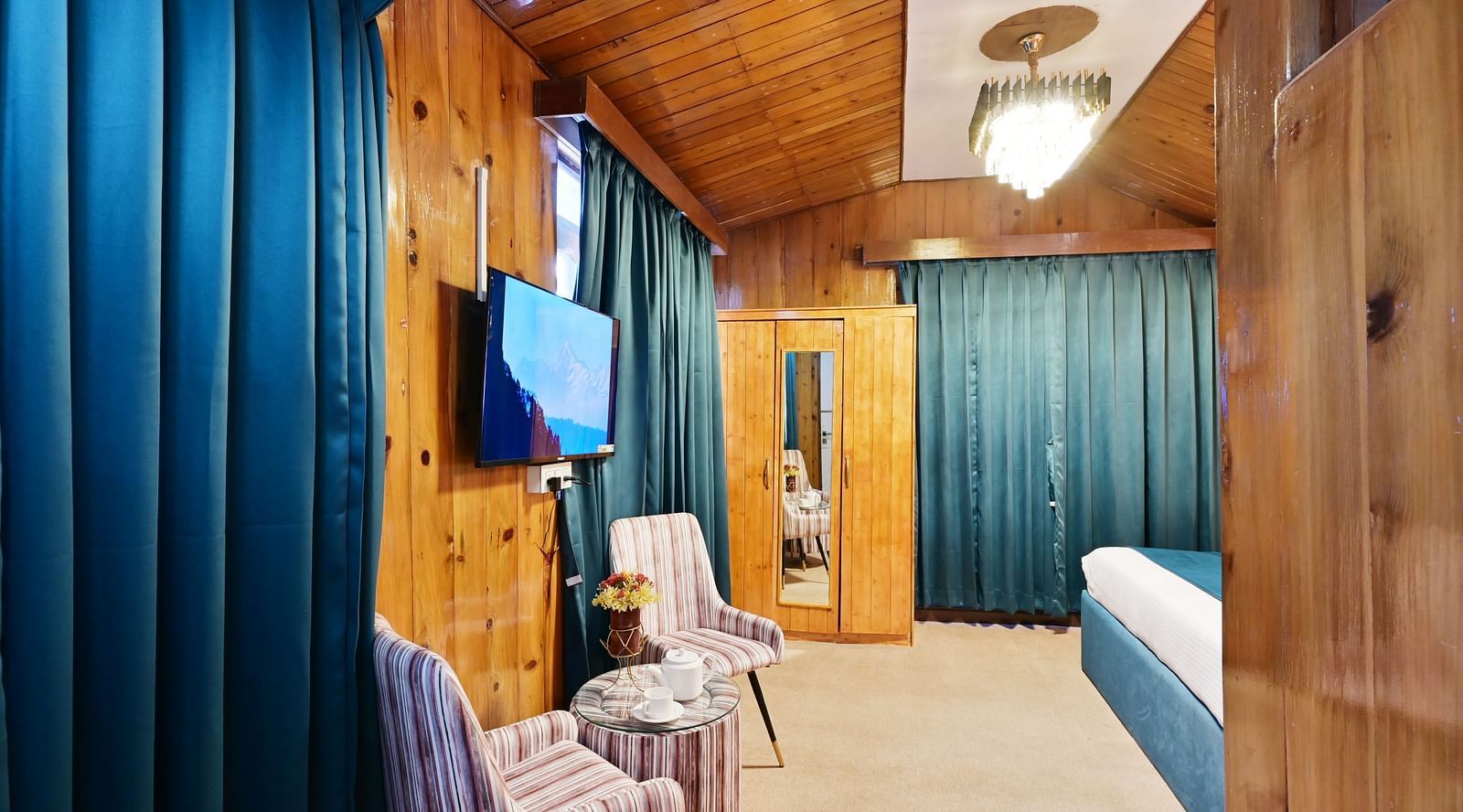 Premium room featuring a king sized bed, wall mounted television, windows with curtains, and warm lighting at Avianna Seven Seas, Darjeeling2