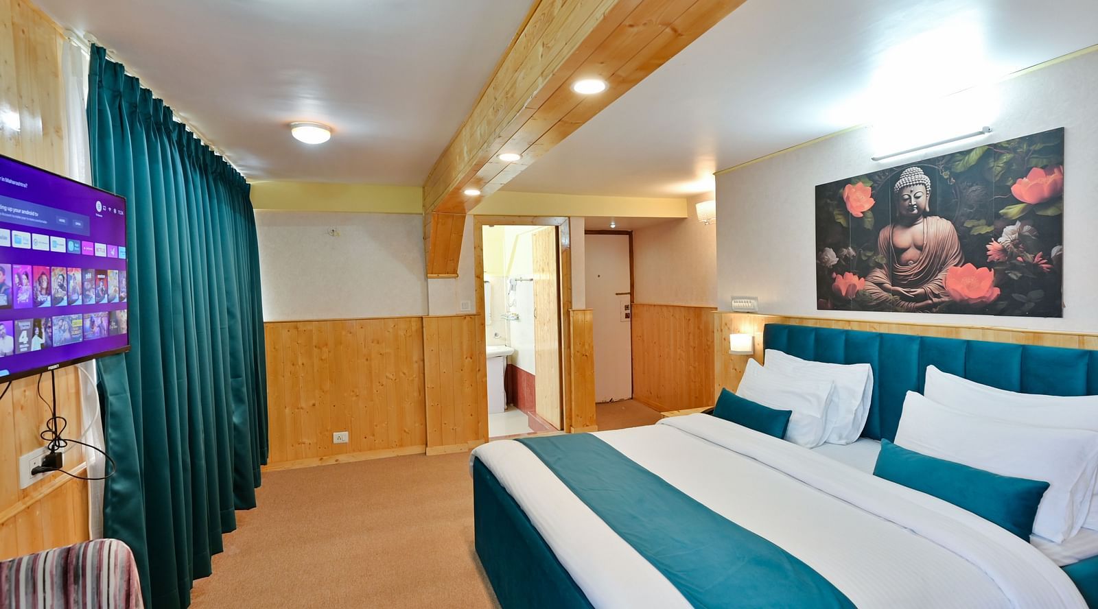 Premium room featuring a king sized bed, wall mounted television, windows with curtains, and warm lighting at Avianna Seven Seas, Darjeeling8