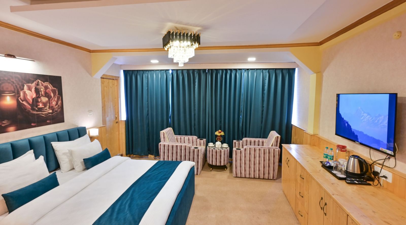 The suite features a spacious bed, large windows stretching along one side of the room, comfortable cushioned furniture, and warm lighting at Avianna Seven Seas, Darjeeling1