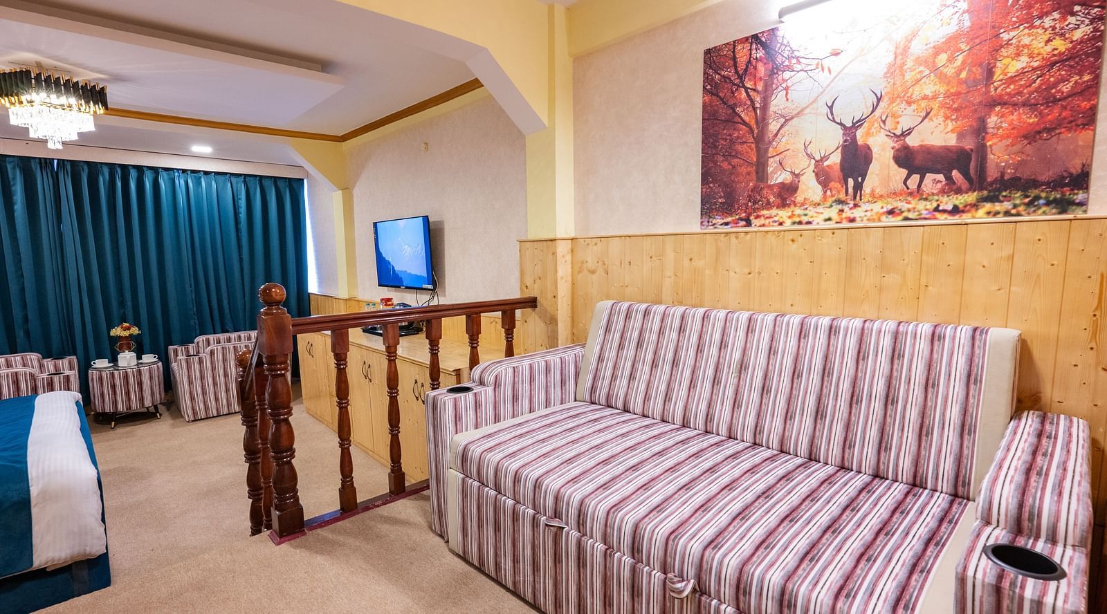 The suite features a spacious bed, large windows stretching along one side of the room, comfortable cushioned furniture, and warm lighting at Avianna Seven Seas, Darjeeling8