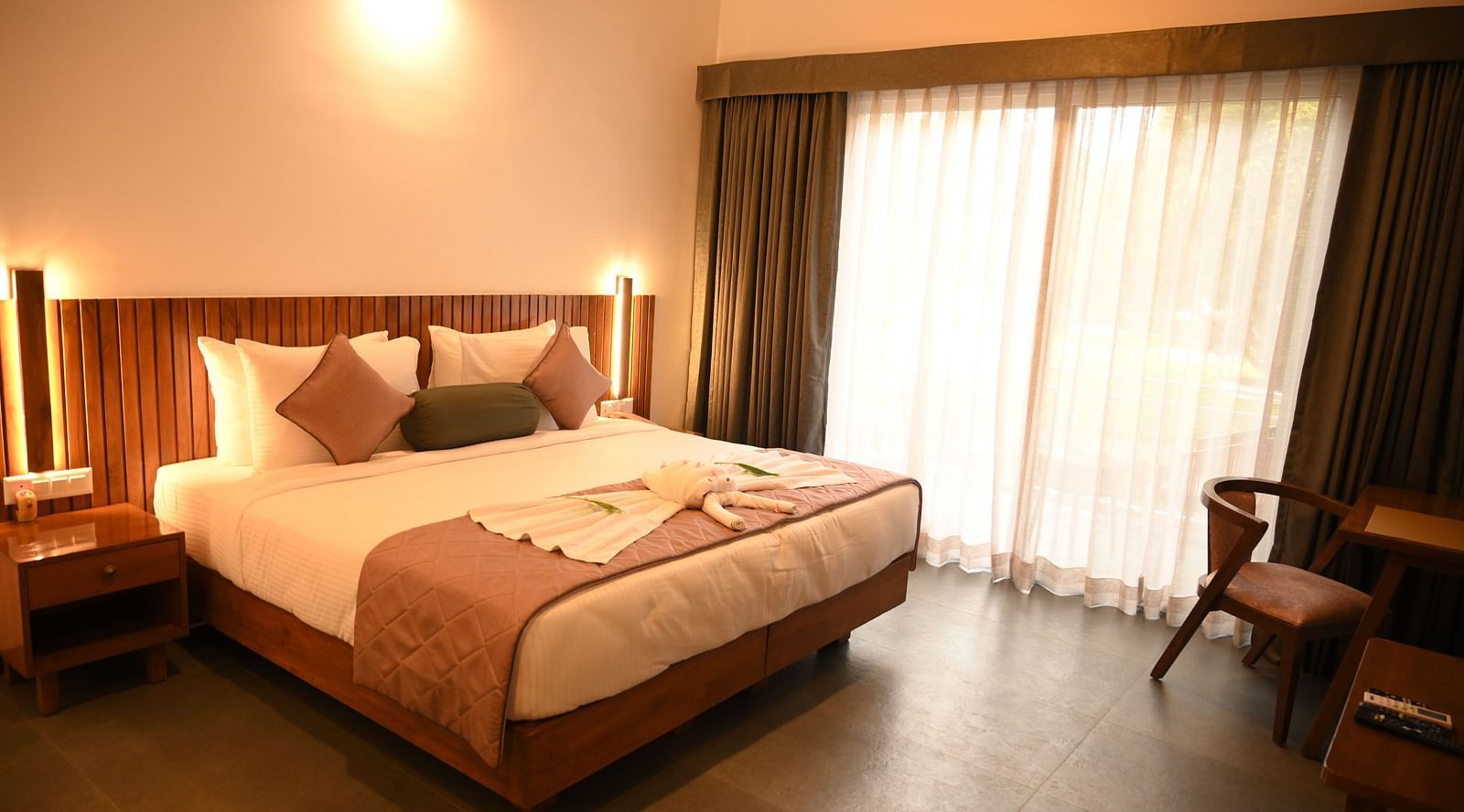 A well room with a double bed at the Deluxe Cottage at Mango Leaf Lake Resort, Pune