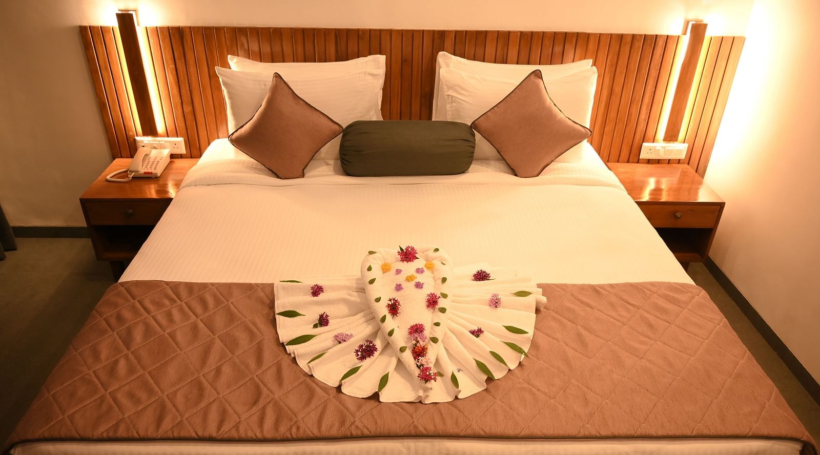 Two swans made of towels and decorated with flowers in the Kutumbh Suite at Mango Leaf Lake Resort, Pune