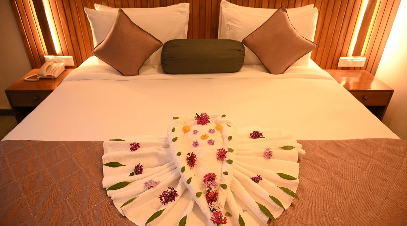 Two swans made of towels and decorated with flowers at the Kutumbh Suite at Mango Leaf Lake Resort, Pune
