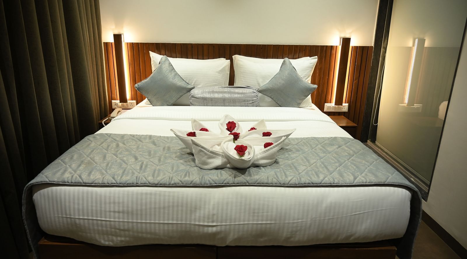 Front view of a A towel shaped in the form of a bouquet kept on the bed at Deluxe room at  Mango Leaf Lake Resort, Pune
