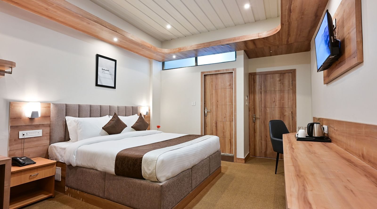 image of the deluxe room at the soma hotel by avianna group, darjeeling with the entrence and bathroom doors in view