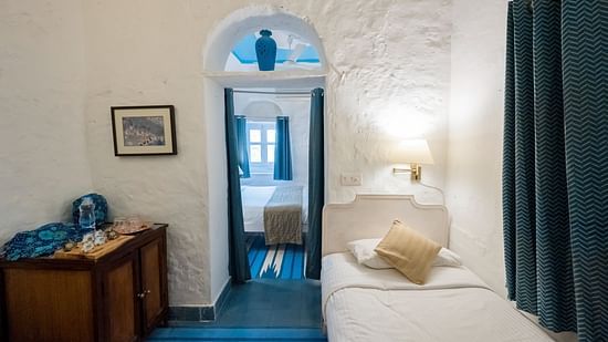 Hill Fort Kesroli 14th Century Alwar - interior view of the Neelkanth Mahal - Countryside View, one of the best hotel rooms in Alwar featuring a single bed and blue curtains