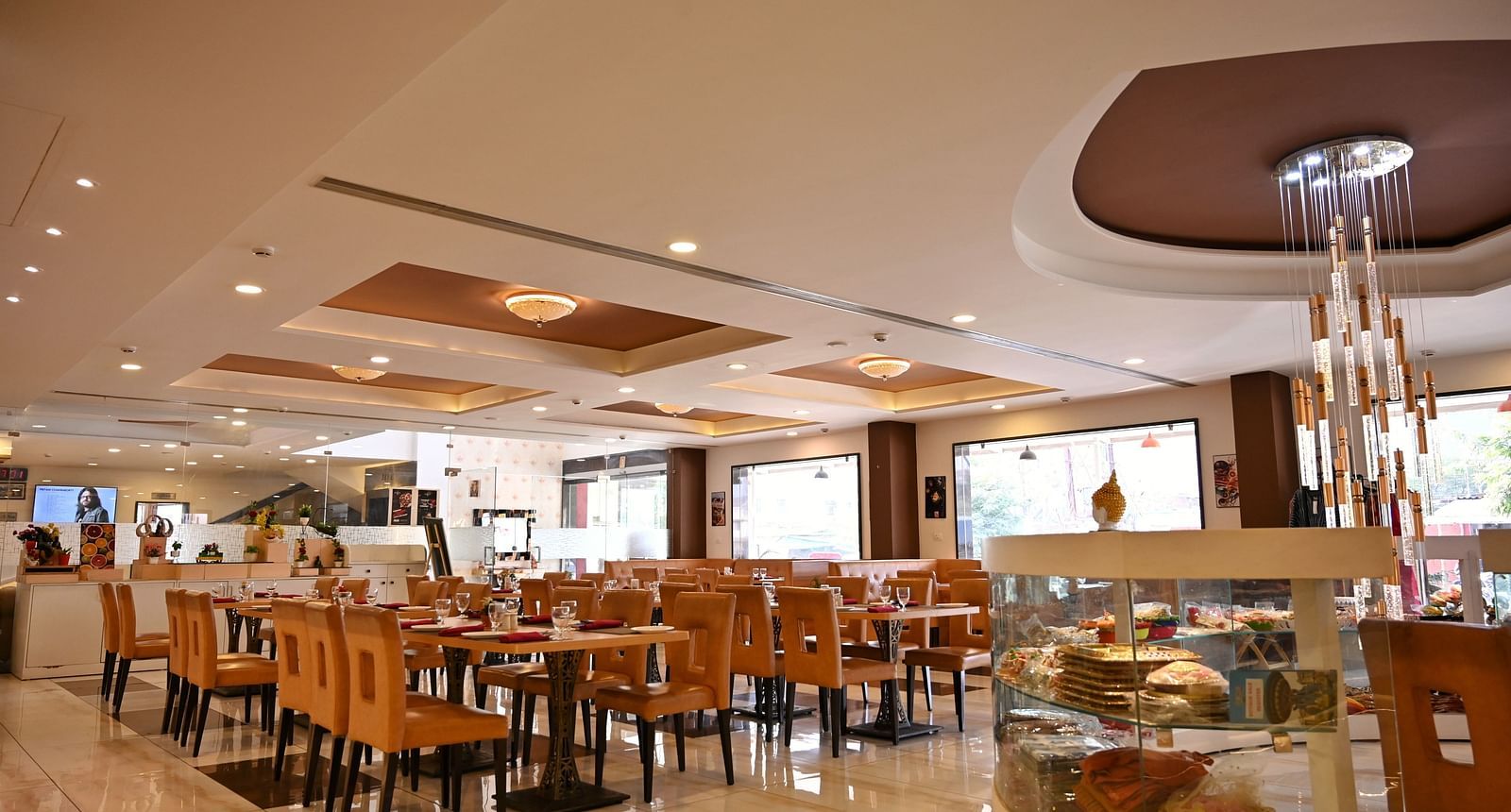 Hotel dining area with neatly arranged tables, contemporary art and a service counter - TGI Insignia, Bhopal