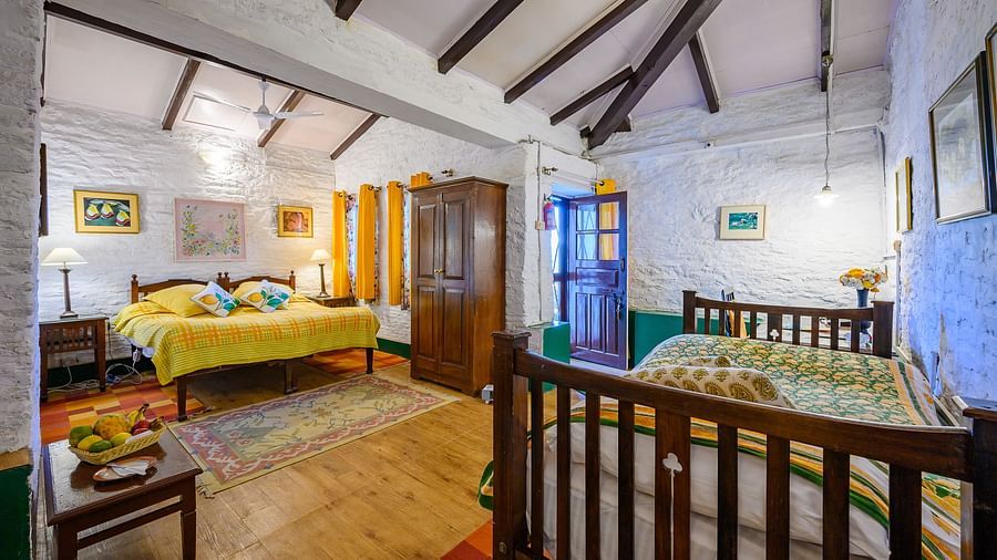The Ramgarh Bungalows - Lemon Room featuring a queen size bed and a single bed with a warorbe and wooden ceiling