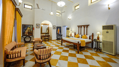A double bed, sofas with coffee table in the centre and a study table inside Maharaja Amarinder Singh room - The Baradari Palace