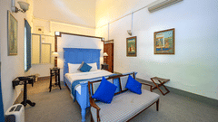 An overview of the Maharani Mohinder Kaur room with a double bed and sofa in front of the bed - The Baradari palace