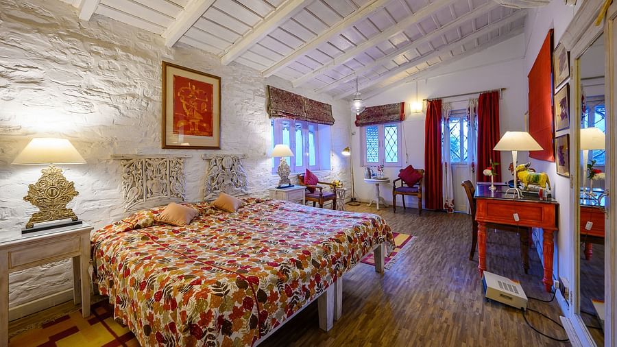 Gitonde room with two single beds joined together and a big wall mirror, along with room amenities like ceiling fan and a work desk - Ramgarh Bungalows, Nainital.